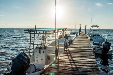 Embarcaciones de buceo atracadas en el muelle privado, que sale sobre el frente de arrecife