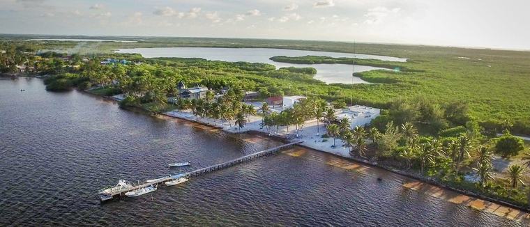 Xcalak desde el aire — el poblado, su muelle y la laguna detrás